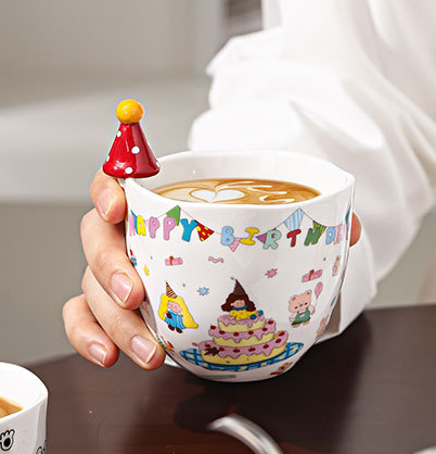 Tasse tenue dans la main de gâteau de chapeau rouge