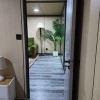 Maison conteneur extensible 20 pieds, structure noire, 2 chambres avec terrasse couverte et auvent pour complexe de glamping