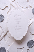 Suite d'invitations de mariage de luxe élégante en carton texturé gaufré avec lettrage en relief, motif floral blanc gravé, et carte RSVP détaillée