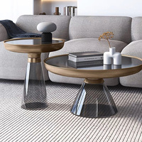 Table basse d'appoint moderne pour salon avec base conique en verre fumé, bordure en métal doré et dessus en verre noir