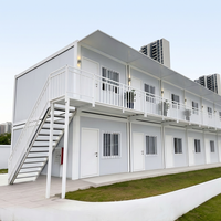 Maison modulaire à deux étages en conteneurs, cabane préfabriquée à ossature acier avec balcon et couloir pour hébergement, bureau ou location.