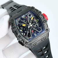 Montre mécanique à tourbillon intégré avec boîtier en forme de barillet en fibre de carbone, bracelet en caoutchouc et fond transparent.