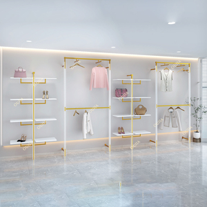 Étagère de <span class=keywords><strong>magasin</strong></span> de vêtements en métal doré brillant personnalisée, support à sacs en acier inoxydable, présentoir mural pour chaussures, présentoir pour chaussures et sacs - Product Image 1