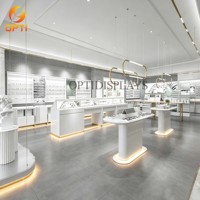 Îlot d'exposition haut de gamme en or blanc pour opticien, avec comptoir en verre et éclairage LED pour magasin de vente de lunettes
