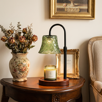 Lampe chauffe-bougie en verre vert style forêt, bras en métal noir mat réglable en hauteur, base en bois irrégulière en forme de nuage