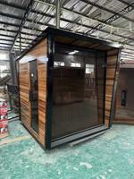 Sauna moderne en cèdre rouge avec cadre noir, verre haut et chauffage à pierres, pour jardin, vente en gros