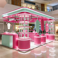 Kiosque de bijouterie rose pastel et menthe, stand modulaire avec présentoirs cylindriques éclairés par LED