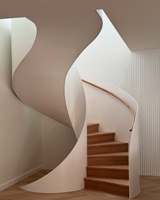 Escalier moderne en métal courbé avec toboggan et éclairage mural LED, garde-corps en verre, pour usage intérieur en villa