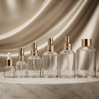 Vente en gros de flacons pulvérisateurs ronds en verre transparent avec pulvérisateur en aluminium doré pour l'emballage de parfums et de cosmétiques