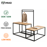 Table de présentation et portant à vêtements combinés avec cadre en métal noir et dessus en bois clair