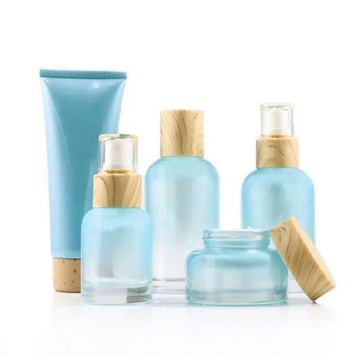 Özelleştirilmiş cilt bakım kremi kozmetik setleri degrade mavi renk yüz losyonu cam şişe ve kavanozlar ahşap tahıl ile kap