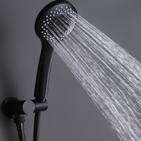 Système de douche noir mat avec plaque de fixation ronde, commandes à double levier, bras courbé, pommeau pluie, jet réglable, douchette à main ronde