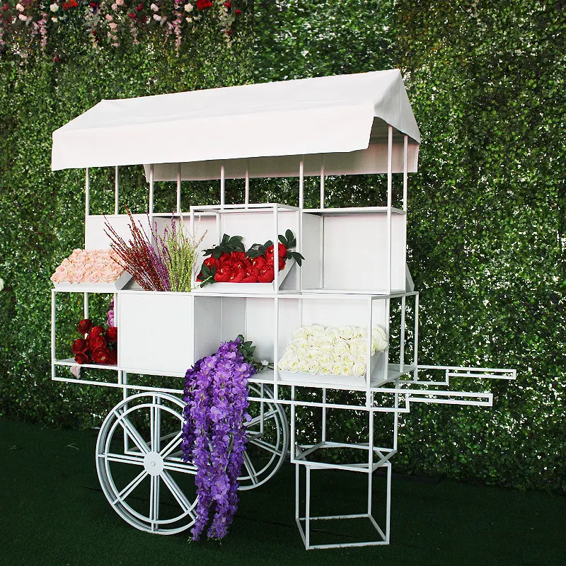 結婚式の装飾のための屋外の花とキャンディーカートを使用して白いイベントパーティーをカスタマイズする