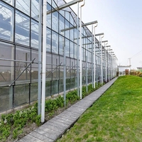 Serre agricole professionnelle de grande taille en verre, structure multi-voûtes avec système de contrôle environnemental complet