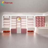 Comptoir de présentation de luxe en or blanc pour produits de soin et parfums, avec étagères LED ovales lumineuses et vitrines en verre pour l'image de marque de détail de produits de beauté