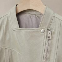 Blouson court en cuir souple vert pâle frais, col montant mini, patte de boutonnage diagonale, boutons-pression métalliques, ourlet à volants 3D fendus