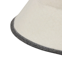 Un gorro de sauna de lana pura color crema que convierte la lambda griega en un distintivo de marca y convierte cada sala de vapor en una declaración de diseño.