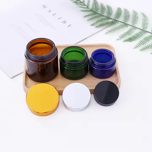 Tarro de vidrio redondo de 50g/100g transparente/negro/verde/azul con hombro inclinado y tapa de plástico dorada/negra - Product Image 6
