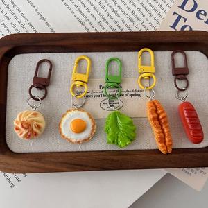Porte-clés mignon en résine sur le thème du petit-déjeuner : œuf frit réaliste, saucisse et pain vapeur avec mousqueton coloré - Product Image 1
