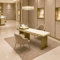 Table de présentation de bijoux sur mesure avec vitrine en verre, bois blanc crème, finition en métal doré pour les bijouteries de luxe