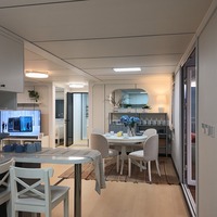 Maison modulaire préfabriquée avec véranda avant, balustrade et grandes fenêtres pour une vie en plein jardin