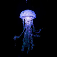 Luminaires suspendus effet méduse scintillante pour estomper les reflets des plafonds acoustiques carrelés, idéaux pour les boutiques de vêtements de marié et les présentoirs de sol pour les fêtes.