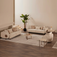 Canapé moderne incurvé trois places pour salon, avec dossier rigide rembourré en mousse, revêtement en tissu beige et base métallique, idéal pour appartement ou salon.