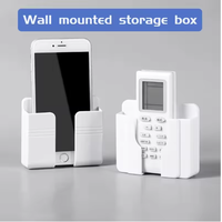 Support mural pour téléphone portable multifonctionnel populaire, nouveau, adhésif, support de chargeur mobile avec télécommande, support mural en plastique