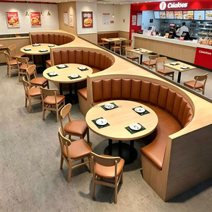 Banqueta Curva de Pared en Tono Claro, Tapicería Naranja con Mechones Verticales, Mesa Redonda, Proyectos de Renovación de Cantinas de Comida Rápida - Product Image 1