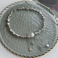 Collier ras du cou tendance 2027 avec perles baroques irrégulières, paillettes dorées et perles empilables en argent, style minimaliste