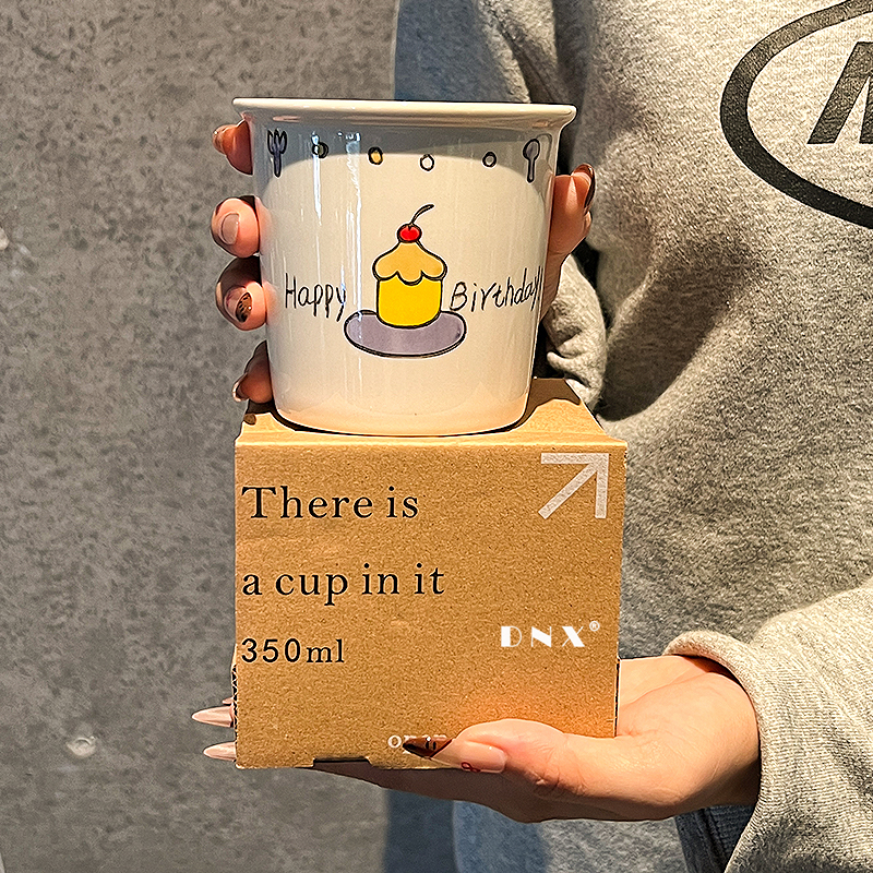 Joyeux anniversaire, tenant une tasse