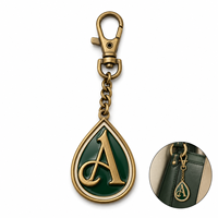 Élégante étiquette de sac personnalisée en laiton antique en forme de lettre goutte d'eau avec feuille de laurier en émail vert foncé et fermoir mousqueton sur chaîne gourmette