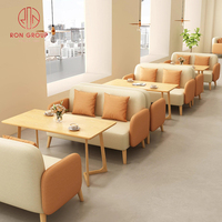 Ensemble de mobilier de restaurant commercial : Canapés deux places beige et vert, table basse ovale en bois moderne et durable avec pieds géométriques