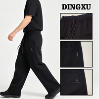 Pantalon de survêtement noir pour homme, coupe large et droite, taille élastique avec cordon de serrage, ourlet ouvert, poches latérales, style streetwear décontracté minimaliste