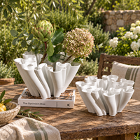 Vase en céramique blanche avec un design sculptural fluide pour fleurs et décoration intérieure
