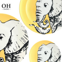 Service de table en porcelaine fine série animale, décor jaune mat, comprenant tasses et soucoupes, assiette de présentation en céramique motif éléphant