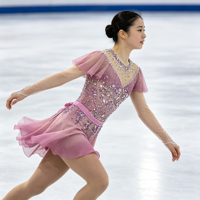 Robe de patinage artistique rose poudré à manches volantées, col en maille, nœud au dos, strass appliqués pour la compétition et la performance