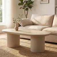 Table basse ovale moderne de style industriel avec piétement cylindrique cannelé blanc crème, mobilier minimaliste pour salon et aménagement intérieur