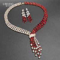 Ensemble collier et boucles d'oreilles en zircone vert émeraude, plaqué or, avec nœud croisé et franges asymétriques multi-rangs