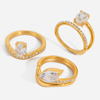 Cincin jari bergelombang bertumpuk dengan permukaan cermin poles premium, warna emas 18K, bertabur rhinestones berkilauan, untuk tampilan pesta koktail.