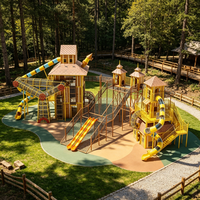 Structure de jeu personnalisée en forme de maison dans les arbres avec plusieurs tours, toboggan et filet de cordes pour parc à thème commercial