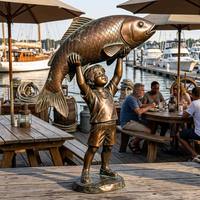 Statue de petit garçon tenant une carpe géante en bronze antique pour la décoration du pont d'un restaurant de marina, statue en bronze