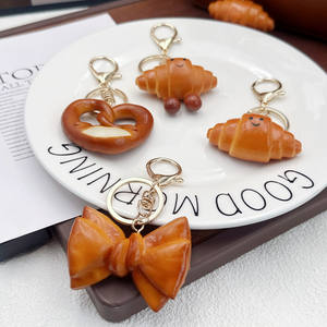 Breloque de sac et porte-clés en PVC, mignonne, légère, en forme de pain, de bretzel ou de croissant, avec nœud, accessoire de bijouterie pour sac à dos - Product Image 2