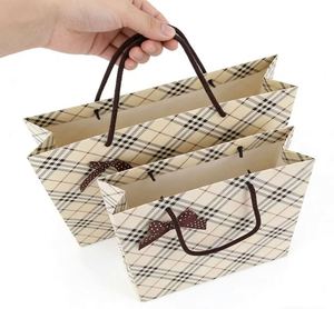 Bolsa de Papel Elegante Color Piel con Diseño a Cuadros, Lazo Marrón Premium, Fondo Crema, Estilo Sofisticado con Patrón de Rejilla - Product Image 2