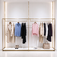 Portant à vêtements pour boutique, structure tubulaire dorée, table de présentation en marbre avec plateau en verre, rail de suspension, CE ETL, vente en gros et au détail