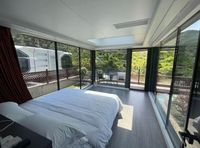 Villa capsule spatiale futuriste et épurée, module de vie modulaire, camping-club panoramique sur la falaise avec verre incurvé