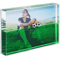 Cadre photo liquide en acrylique avec flotteurs de ballons de football et de coupes dans un fond de gazon, paillettes dans le cristal haute clarté, OEM