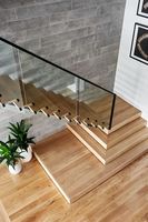 Escalier flottant en bois massif avec éclairage LED, poutres en acier invisibles et garde-corps en verre trempé