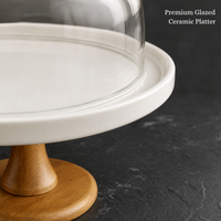 Support à gâteau rond blanc surélevé avec bordure conique en bois, dôme en verre transparent et bouton sphérique pour présentation sur table à manger