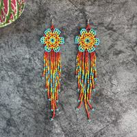 Boucles d'oreilles pendantes bohèmes faites à la main avec perles colorées en forme de fleur, tissées à la main avec des perles de riz et des pompons floraux